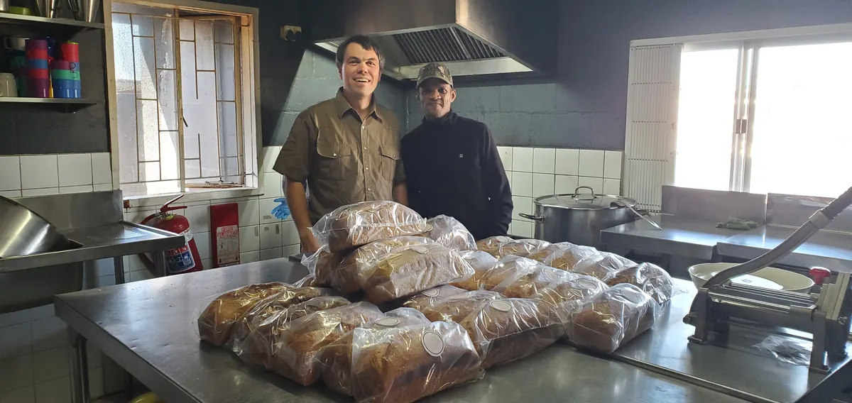Loaves of bread piled high in a community kitchen, ready to be shared